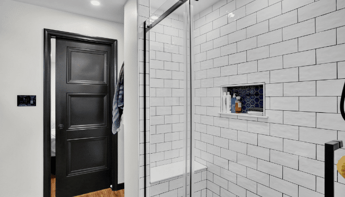 Walk-in shower with white subway tile and built-in niche